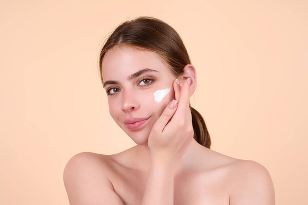 Beautiful woman applying moisturizer cream her face. Beauty concept. Skincare and pampering. Anti aging cream. Young model applyed cream. Girl applying cosmetic cream treatment on face