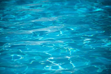 Su arka planı, dalgalanma dalgaları. Mavi yüzme havuzu deseni. Deniz yüzeyi. Yüzme havuzunda su ve güneş yansıması. Kopyalama alanı olan pankart