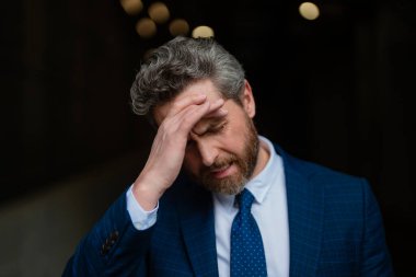 Üzgün iş adamının migreni tuttu. Güçlü baş ağrısı olan bir adam. Stresli, baş ağrısından yorgun iş adamı. Baş ağrısı, yorgunluk ve stres, migren. Baş ağrısı konsepti