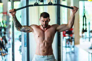 Sportsman muscular man workout in gym. Athletic man exercising with dumbbell. Fitness, sports concept, sport club, fitness center. Workout in gym. Sexy guy bodybuilder with perfect muscles body