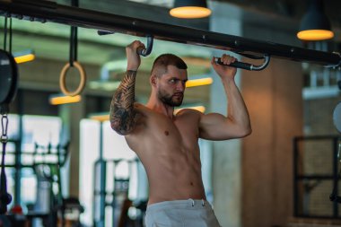 Handsome man preparing for workout. Sport. Weight workout. Guy doing bodybuilding workout in gym. Sport, bodybuilding and fitness. Man exercising with dumbbell. Hard workout