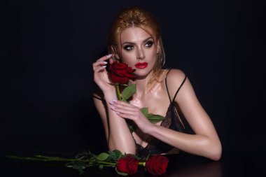 Stüdyo güzelliği portresi. Kırmızı gül çiçekli güzel bir kadın.
