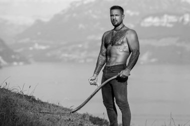 Çim çiftliğindeki İspanyol adam. Ekoloji konsepti. Çıplak gövdeli seksi bir çiftçi. Çiftlikteki kaslı seksi çiftçi. Kırsal kesimdeki çiftlikte güçlü üstsüz çiftçi. Çim tarlasında çıplak çiftçi