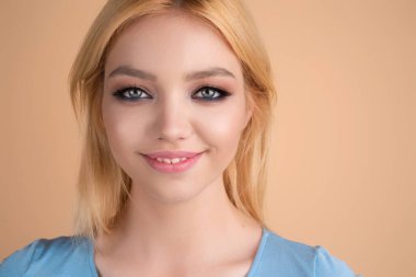 Gülen surat. Kadın yüzü mutlu bir gülümseme. Gülümseyen genç kızın yakın portresi. Dişleriyle gülümseyen, mutlu bir yüz ifadesiyle kameraya bakan genç bir kadın. Gülümseme. Gülen surat.