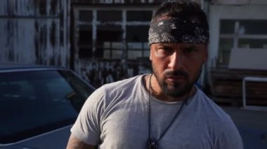 Suç sokağında dövmeli gangster. İspanyol suç çetesi üyeleri. Gangsta Crimes tarzı. İspanyol bir hırsız. Etnik kızgın suç adamı. Dışarıdaki güçlü vücutta dövmesi olan bir suçlu. Sokak tarzı