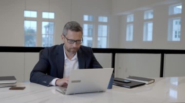 Office worker with laptop at office. Ofice employee remote working in modern office. Businessman have on line meeting. Business man using computer in office. Modern offices workplace