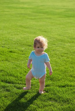 Bebek bezi pantolonuyla parkta yürüyor.