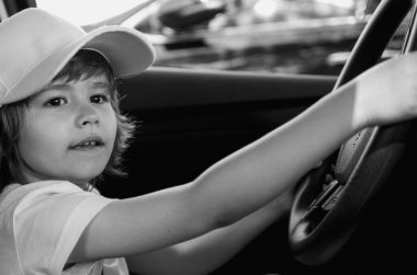 Küçük Sürücü. Araba kullanıyormuş gibi yapan sevimli bir çocuk. Çocuk arabada, elleri direksiyonda. Çocuk Sürücüsü. Küçük çocuk araba kullanıyor. Çocuk direksiyonda oturuyor. Arabayla oynayan çocuk. Hayal et.