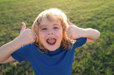 Spring Park 'taki çocuk portresi. Kapalı yüzlü çocuk yaz parkında dışarıda oynuyor.