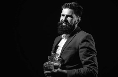 Yakışıklı sakallı iş adamı pahalı bir viski içiyor.