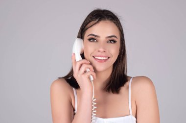 Retro hatta konuşan seksi bir kadın. Elinde antika telefon tutan kadın portresi. Telefon ahizeli poster kızı. Eski model telefon ahizesi. Poster stili kız elinde telefon tüpü, telefon ahizesi