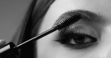 Kaşlar şekilli. Kadının kaş makyajı yaptırmasına yakın çekim. Makro kaşına fırçayla kozmetik uyguluyordu. Mükemmel bir kaş şekli, kahverengi göz farı ve uzun kirpikleri. Şekli kaşlar