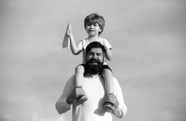 Babalar Günü. Baba ve oğul birlikte oynuyorlar. Mutlu bir babanın portresi. Oğlunu sırtında taşıyor ve yukarı bakıyor.