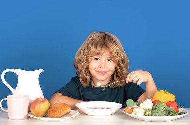 Çocuk çorba içiyor. Çocuk Kithen 'da sağlıklı yemek yiyor. Bebek kaşıkla çorba içer