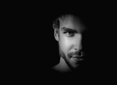 Erkek yüzü yakın çekim. Seksi erkek yüzü, stüdyo resmi. Çekici bir adam gölgede, kameraya bakıyor. Gölgelerdeki genç adamın seksi ve çekici yüzü. Güzel seksi model yakın plan. Yüzler