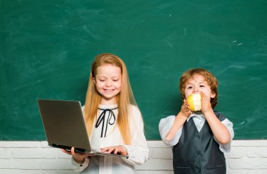 Çocuk tahtanın arka planında sınıfta öğreniyor. Okulda geniş bir şekilde gülümseyen mutlu ruh hali. Bir sınıfta küçük çocuk kız ile sevimli küçük okul öncesi çocuk çocuk. Birinci sınıf