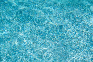 Su arka planı, dalgalanma dalgaları. Mavi yüzme havuzu deseni. Deniz yüzeyi. Yüzme havuzunda su ve güneş yansıması. Kopyalama alanı olan pankart