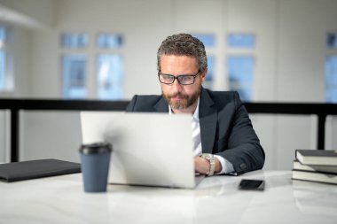 Ofis işyeri. Ofiste dizüstü bilgisayarla çalışan yakışıklı bir iş adamı. Klavyede daktilo yazan iş adamı, online iş toplantısı. Ofiste çalışan bir iş adamı. Bilgisayarı kullanan bir ofis çalışanı