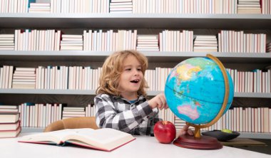 School and students in classroom. Education kids. Child pupil student in the school class. Studying and learning concept. School boy in the library near school supplies. Kid learn geography with globe