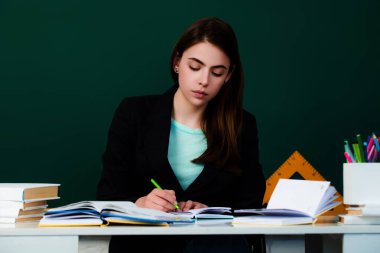 Yeni öğretmen ev ödevini kontrol ediyor. Çekici kız öğrenci ya da yeni öğretmen. Dil ve eğitim konsepti öğreniyorum. Genç bayan öğretmen. Öğrenci sınav için hazırlanıyor.