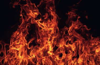 Siyah arka planda yangın alevleri. Ateş, izole edilmiş, soyut bir yapı. Yanma efektiyle yanan bir patlama. Duvar kağıdını ateşle, kopyalama alanı ile soyut sanat deseni