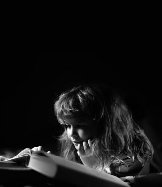 Çocuk yatakta sihirli bir kitap okuyor. Çocuk evde kitap okurdu. Eğitim ve okuma kavramı