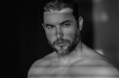 Kozmetik, vücut bakımı ve spa tedavisi. Beyaz arka planda izole edilmiş erkeksi, çekici, üstsüz bir adam portresi. Çekici adamın yakın plan portresi.