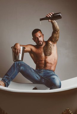 Lüks elit eğlence. Lüks hayatı şampanya şişesi ile kavramı. Acımasız adam, banyo içine dökülen şampanya ile. Lüks hayat. Lüks elit alkol ile çekici erkek