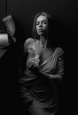 Baştan çıkarıcı kadın yüzü. Orkide çiçeği ve seksi vücuduyla poz veren şehvetli genç bir kadın. Çok seksi bir mankenle. Güzel surat. Şehvetli kız, seksi model portresi. Doğal güzellik.