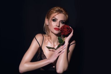 Sıska, seksi, çıplak omuzlu, kırmızı güller tutan, stüdyo arka planında soyutlanmış bir kadın. Çiçekli şehvetli bir kızın portresi