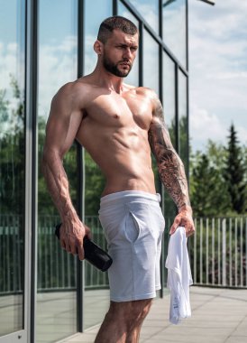 Muscular men lifting weights. Powerful male fit model doing workout in gym. Man lifting dumbells, strong athletic fit man doing exercises with dumbbells. Weightlifting workout. Fitness workout