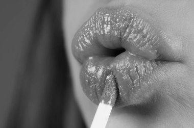 Dudaklarına kırmızı ruj süren bir kadın. Seksi kız ruj sürmüş. Kırmızı dudaklar makyaj malzemesi. Dudaklara ruj sürüyorum.