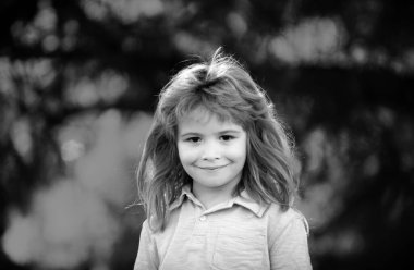 Bahar çocukları portresi. Gülümseyen tatlı bahar çocuğunun yakın yüzü. Çocuk duyguları konsepti. Dışarıdaki gülen çocuğun portresi. Sarışın çocuk.