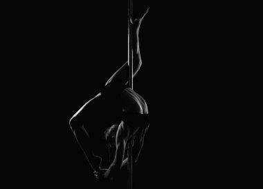 Direk dansı. Kolonda dans eden esnek seksi kız. Güzel esnek kadın vücudu. Siyah üzerine seksi esnek bir kadının moda stüdyosu portresi. Jimnastik ince ve esnek dansçı kadın
