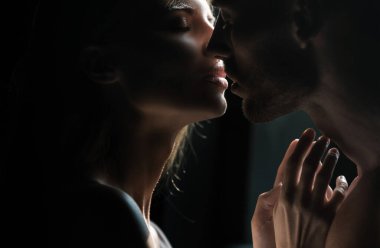 Birbirini kucaklayan, romantizm ve şefkat dolu genç ve güzel bir çiftin yüzünü kapayın. Şehvetli çift öpücüğü. Ben de seni seviyorum. Romantik ve aşk