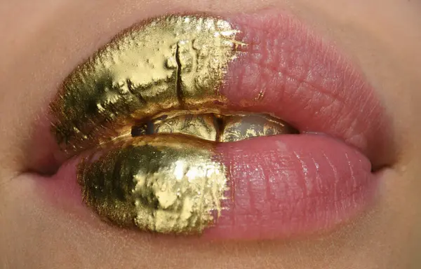 Golden lipstick closeup. Lips with metal makeup. Sexy lips, Metallic lipstick close up. Golden art design