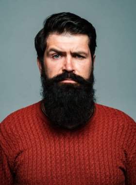 Kendine güvenen adamın sakalı ve bıyığı var. Ciddi ve izole görünüyor. Hipster ciddi adam ifadeyle düşünüyor. Yakışıklı erkek model, yakın çekim yüzü.