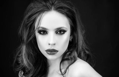 Kırmızı dudakları ve dumanlı gözleri olan zarif bir kadın. Makyajlı yakın plan yüz.