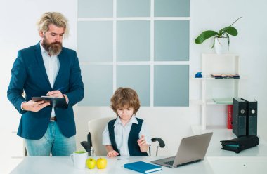 Ofisteki bir iş masasında patronluk taslayan küçük çocuk. İşadamı ekibi yeni bir proje için ofiste çalışıyor. Takım işi. İş ekibi beyin fırtınası yapıyor.