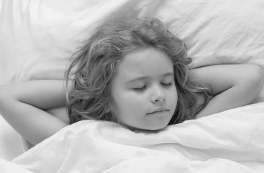 Uyku, uyku konsepti. Sevimli çocuk yatakta uyuyor. Uyuyan çocuk