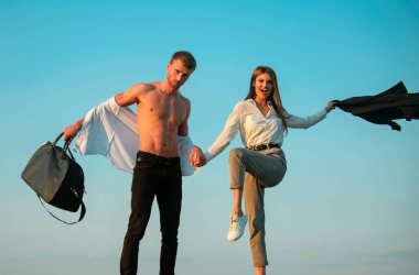 Heyecanlı bir çift. Dışarıdaki heyecanlı ve neşeli özgürlük çifti. Heyecanlı, kaygısız bir çift. Açık tişörtlü bir adam ve kollarını açan heyecanlı genç bir kadın. Bagaj çantalı, gömleksiz, heyecanlı bir adam. Özgürlük çifti