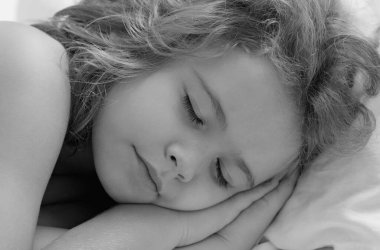 Sessiz bir uyku. Tatlı çocuk yatakta uyuyor. Uyuyan çocuk