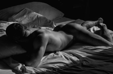 Mans naked body, muscular shoulders. Naked man in bed. Muscular sexy male bum. Gay sexy model. Muscular sexy man with naked torso. Hunk with athletic body. Carefree guy enjoying night