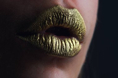 Seksi altın dudaklar, seksi dudaklarda altın ruj, metalik ağız. Şehvetli kadın ağzı. Seksi kız altın dudaklar, altın ağız. Parlak altın ten ve yaldızlı dudaklar. Metalik parlak altın dudak parlatıcısı