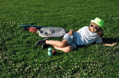 Doğadaki çocuk. Çocuk dışarıda parkta dinleniyor. Yaz haftasonu. Yaz tatili