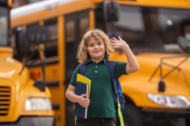 Çocuk okula gidiyor. Okul çocuğu okul otobüsüne biniyor. Amerikan Okulu. Mutlu çocuklar çalışmaya hazır. Amerika 'da öğreniyorum. İlkokulun ilk günü