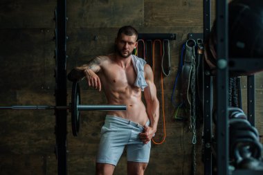 Spor salonunda egzersiz yapan güçlü bir genç adam. Spor kulübünde spor erkek antrenmanı. Genç adamın fitness antrenmanı var. Erkek sporcu egzersiz, spor ve antrenman yapar. İnsanlar spor ve sağlıklı yaşam tarzları