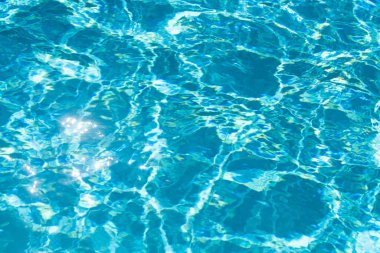 Yüzme havuzunda güneş yansımalı dalgalı su. Dalgalı su arkaplanı