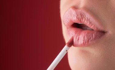 Kırmızı ruj. Dolgun doğal dudaklar için parlak bir makyaj. Ruj ve pudra. Kırmızı dudakları kapat. Pembe ruj. Pomade. Ruj sürüyorum. İşlem sırasında makyaj