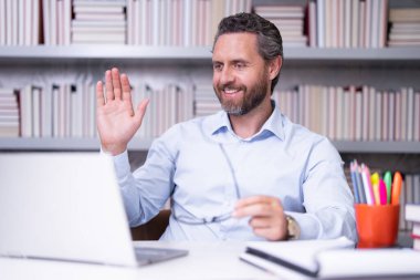 Sınıfta kitabı olan bir öğretmenin portresi. Sınıfta yakışıklı bir öğretmen. Öğretmenler Günü. İyi bir öğretmen. Sınıfta öğretmen. Sınıfta kitapları olan bir adam. Bilgi ve eğitim kavramı